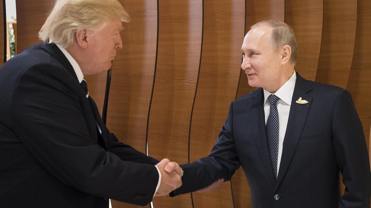 US-Präsident Donald Trump und Russlands Präsident Wladimir Putin begrüßen sich US-Präsident Donald Trump und Russlands Präsident Wladimir Putin begrüßen sich
