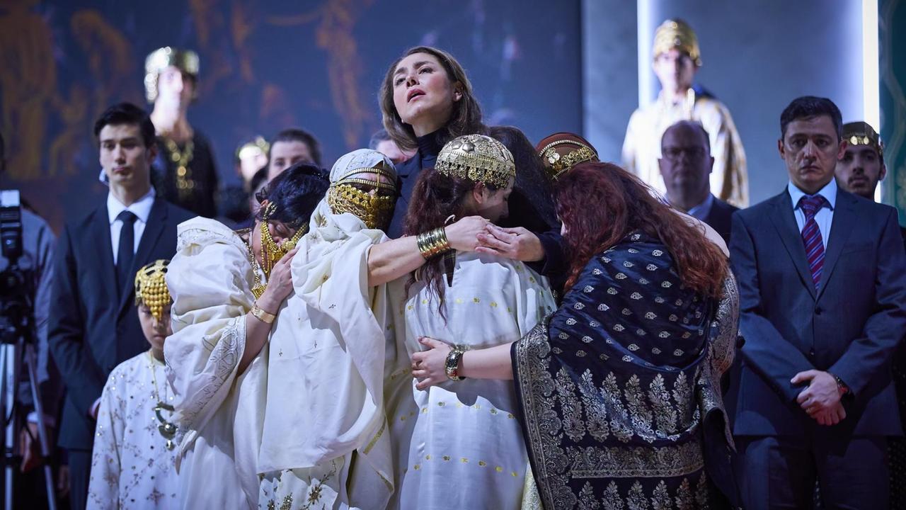 Oksana Dyka in der Nabucco-Inszenierung von Serebrennikow an der Staatsoper Hamburg. Sie wird umarmt von kostümierten Kindern.
