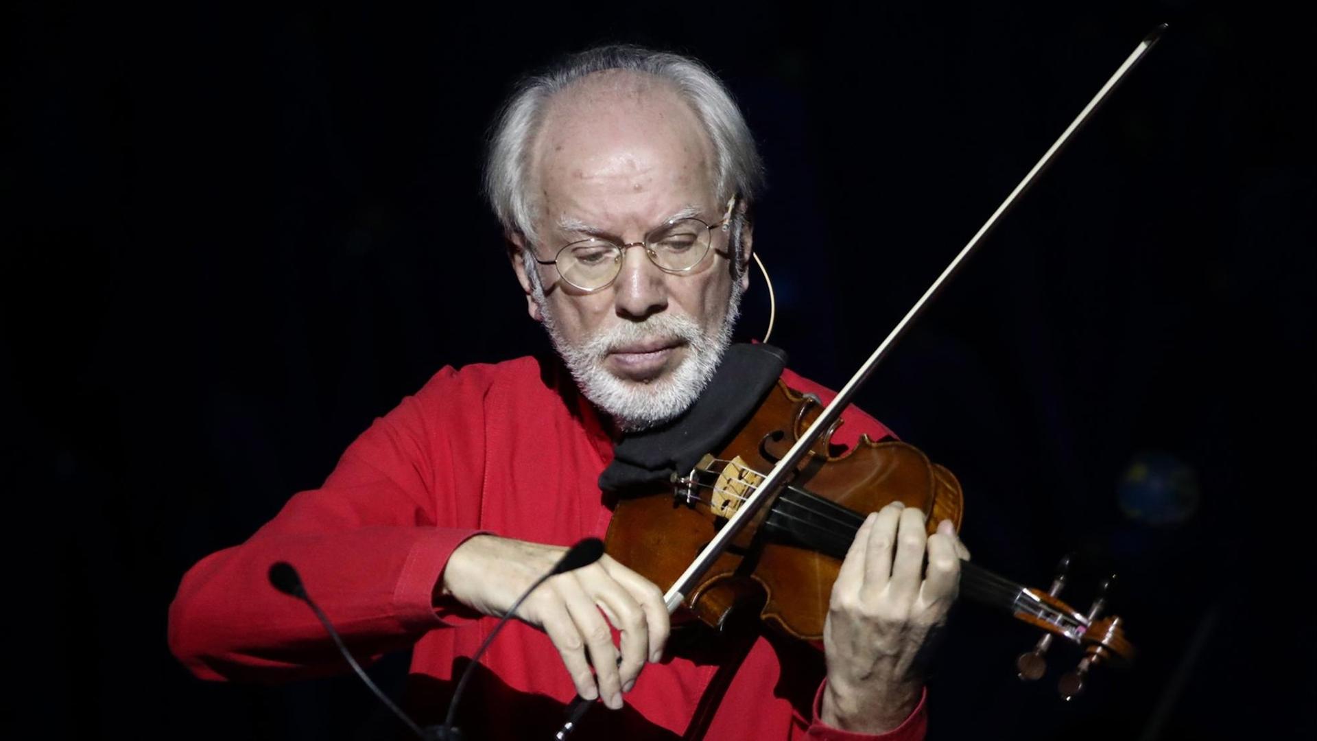 Gidon Kremer, ein Mann mit weißem Bart und Halbglatze, spielt Geige. Gidon Kremer, ein Mann mit weißem Bart und Halbglatze, spielt Geige.