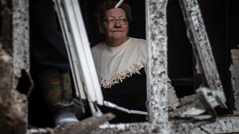 Eine Frau in ihrem zerstörten Haus in Donetsk.