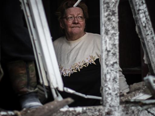 Eine Frau in ihrem zerstörten Haus in Donetsk.