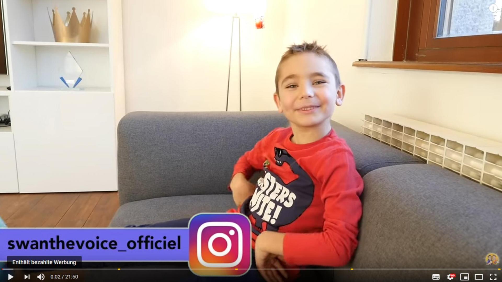 Screenshot eines Videos des YouTube-Kanals "Swan The Voice - Néo & Swan". Der siebenjährigen Swan sitzt strahlend auf dem Sofa. Screenshot eines Videos des YouTube-Kanals "Swan The Voice - Néo & Swan". Der siebenjährigen Swan sitzt strahlend auf dem Sofa.