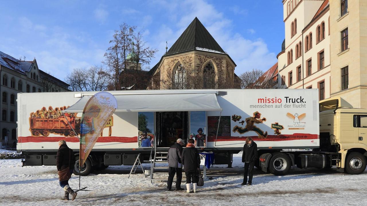 Menschen stehen vor dem missio-Truck mit der Ausstellung "Menschen auf der Flucht". Menschen stehen vor dem missio-Truck mit der Ausstellung "Menschen auf der Flucht".