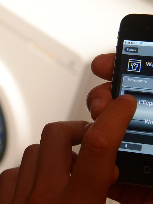 Ein Handy zeigt eine Smartphone-App für die Waschmaschine.