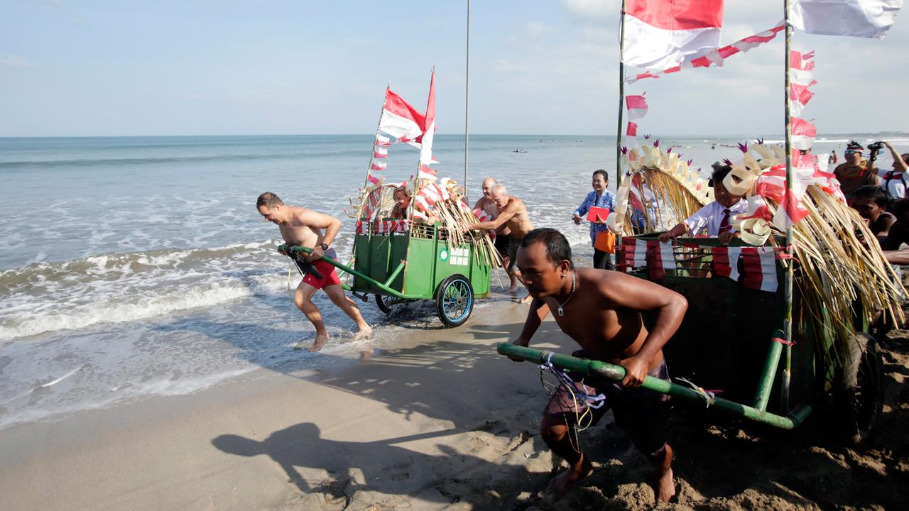 Indonesier und Touristen zelebrieren den indonesischen Unabhängigkeitstag mit einem Wagenrennen am Strand von Bali.