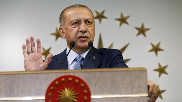 Der Bild zeigt den türkischen Präsidenten Erdogan. Er hält in seiner Residenz eine Rede an die Nation.