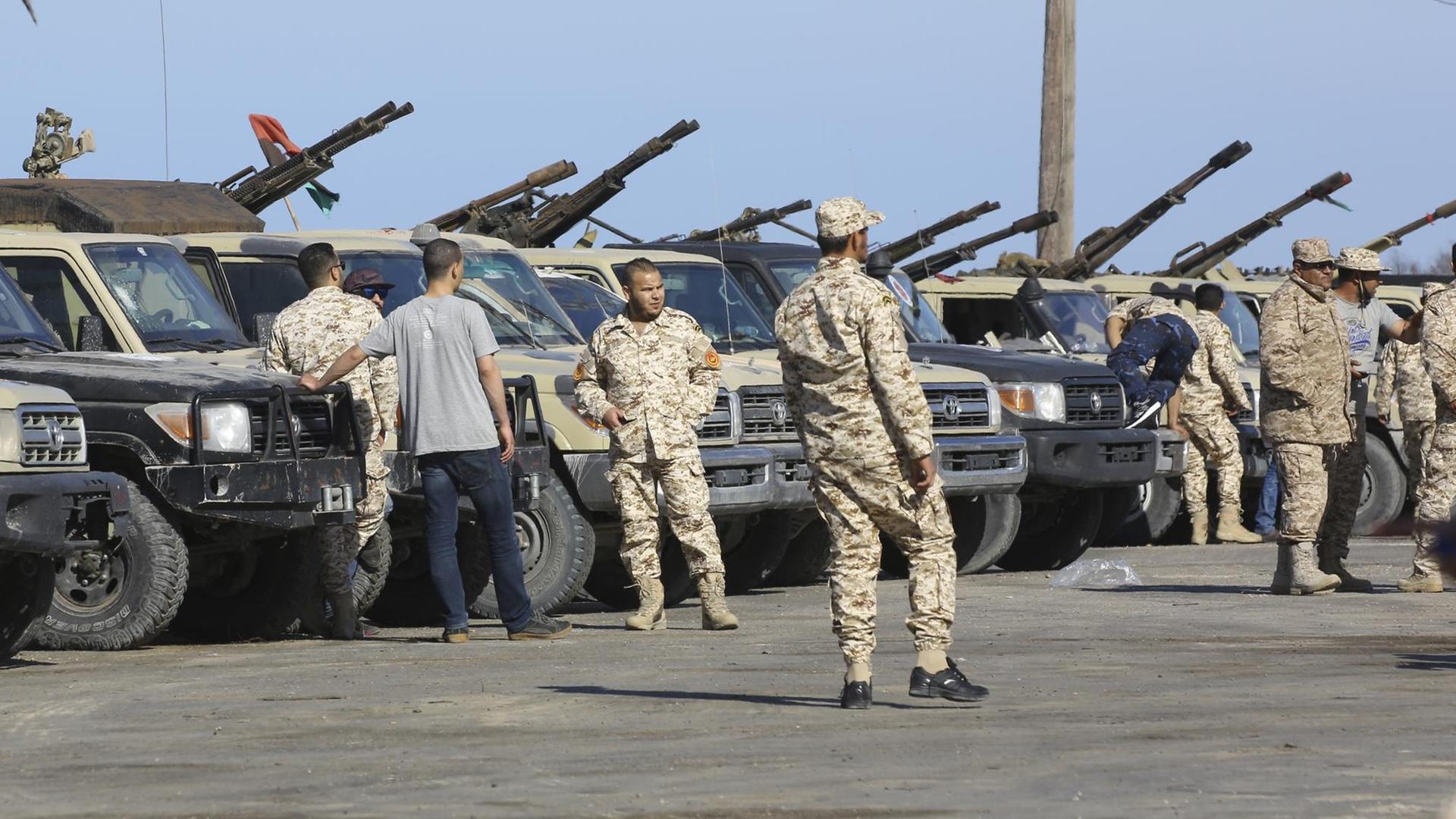 Soldaten der libyschen Einheitsregierung stehen neben Militärfahrzeugen.