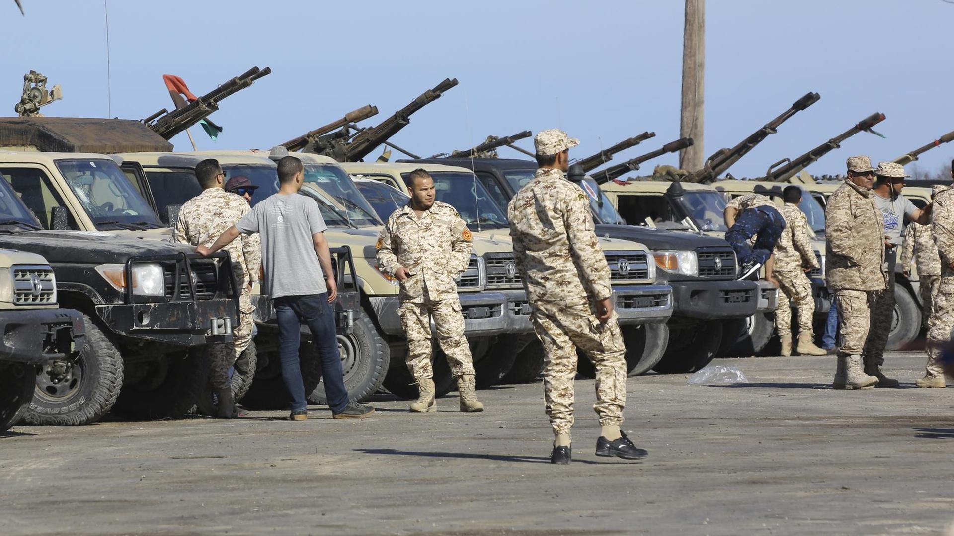 Soldaten der libyschen Einheitsregierung stehen neben Militärfahrzeugen. Soldaten der libyschen Einheitsregierung stehen neben Militärfahrzeugen.