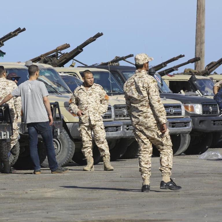 Soldaten der libyschen Einheitsregierung stehen neben Militärfahrzeugen. 
