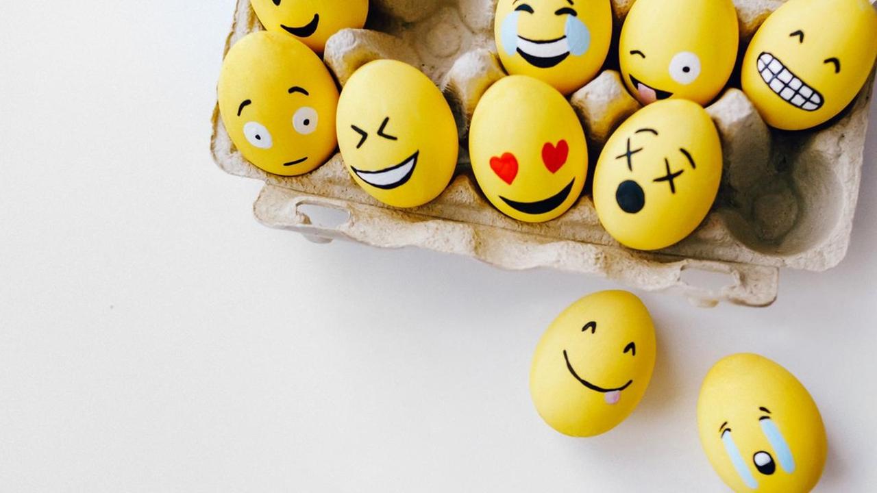 Gelb gefärbte Eier mit aufgemalten, lachenden Gesichtern.