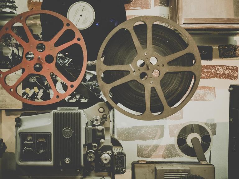 Das Foto zeigt das Innenleben eines alten Kinoprojektors mit eingelegter Filmrolle.