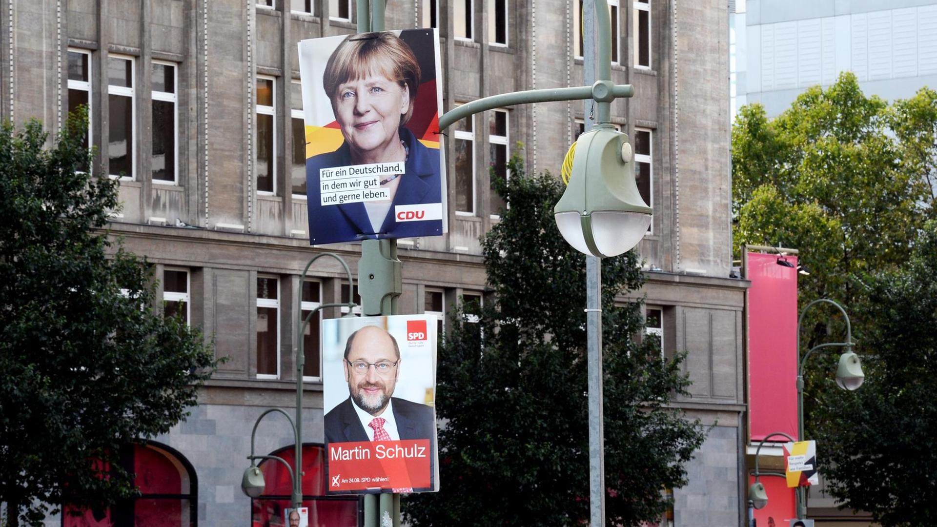 Wahlplakate der CDU mit Bundeskanzlerin Angela Merkel und der SPD mit Spitzenkandidat Martin Schulz sind am 09.08.2017 vor dem Kaufhaus des Westens oder KaDeWe zu sehen. Wahlplakate der CDU mit Bundeskanzlerin Angela Merkel und der SPD mit Spitzenkandidat Martin Schulz sind am 09.08.2017 vor dem Kaufhaus des Westens oder KaDeWe zu sehen.