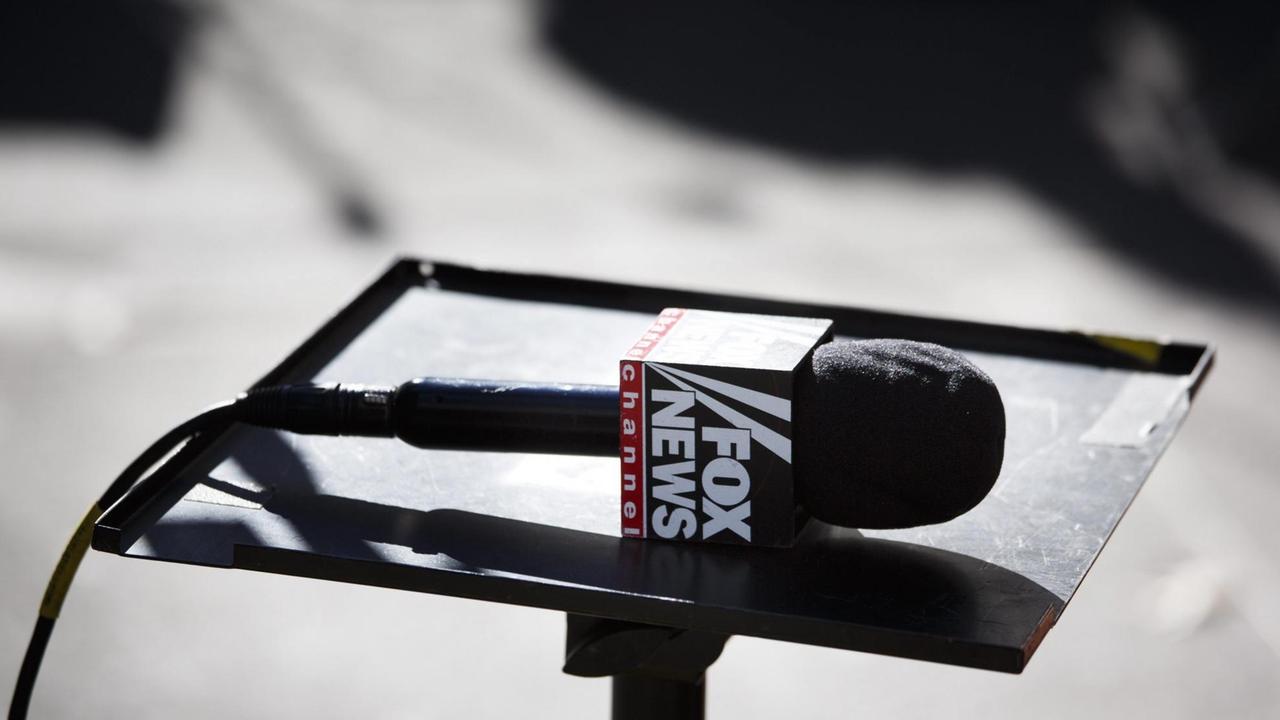 Ein Mikrofon von Fox News liegt auf einem Pult. Ein Mikrofon von Fox News liegt auf einem Pult.