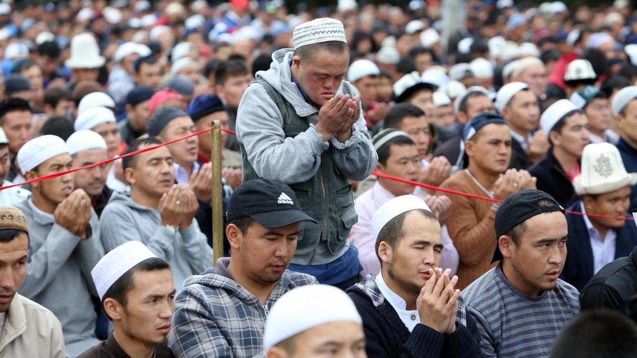 Kirgisische Muslime beten am 05. Juli 2016 während des Eid al-Fitr, dem Fest des Fastenbrechens im Ramadan in Bishkek, Kirgistan. Muslime auf der ganzen Welt feiern den Fastenmonat Ramadan, indem sie während der Nacht beten und zwischen Sonnenauf und -untergang auf Essen und Trinken verzichten. Ramadan ist der neunte Monat im islamischen Kalender. In seinen ersten zehn Tagen wurde nach islamischer Auffassung der Koran herabgesandt.