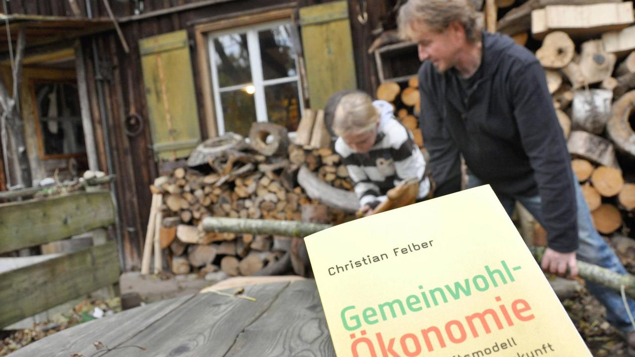Der österreichische Autor und Globalisierungskritiker Christian Felber, im Hintergrund Schreiner Richard Lodziato vor seiner Werkstatt Astelier bei Wangen im Allgäu.