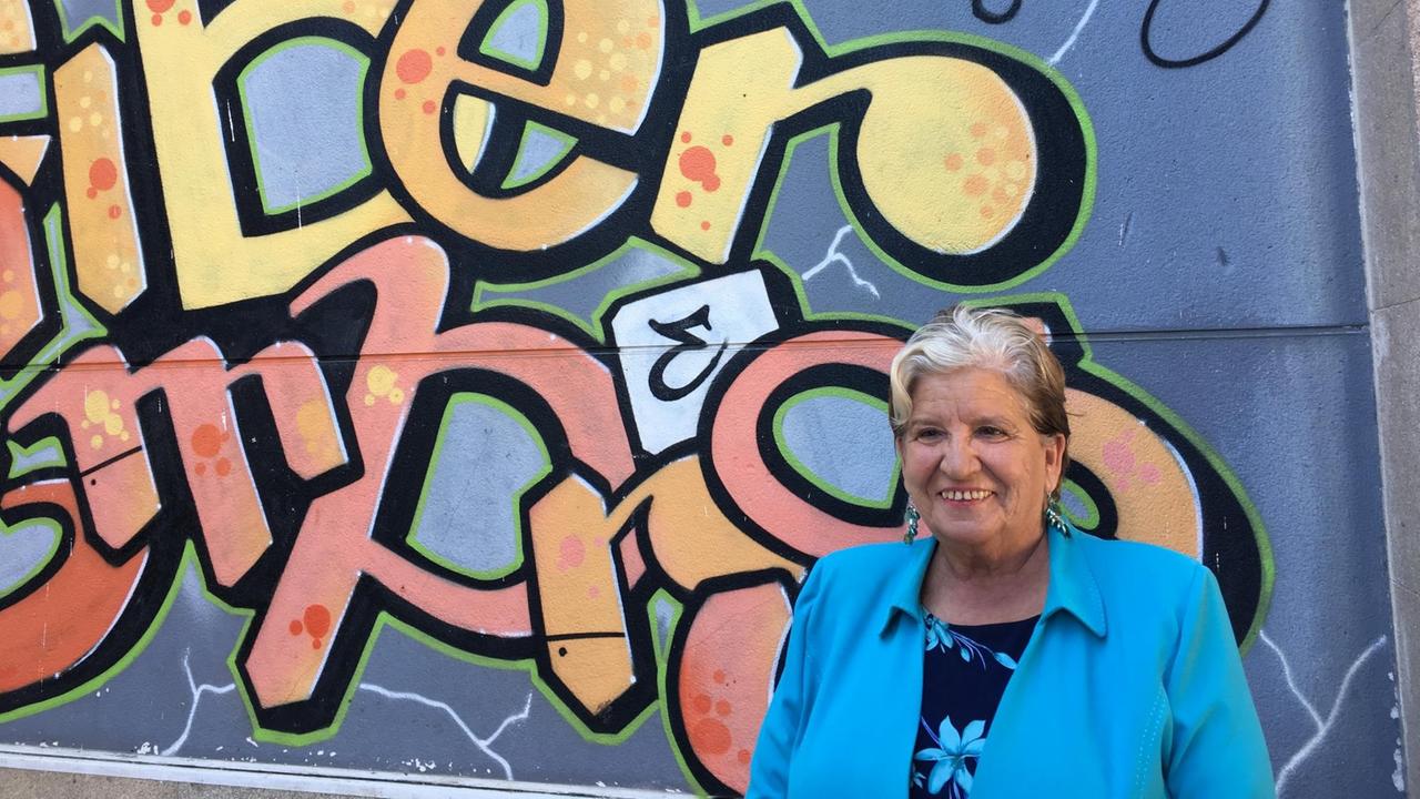 Porträt von Carmen Avendaño vor einer Mauer mit Graffiti. Porträt von Carmen Avendaño vor einer Mauer mit Graffiti.
