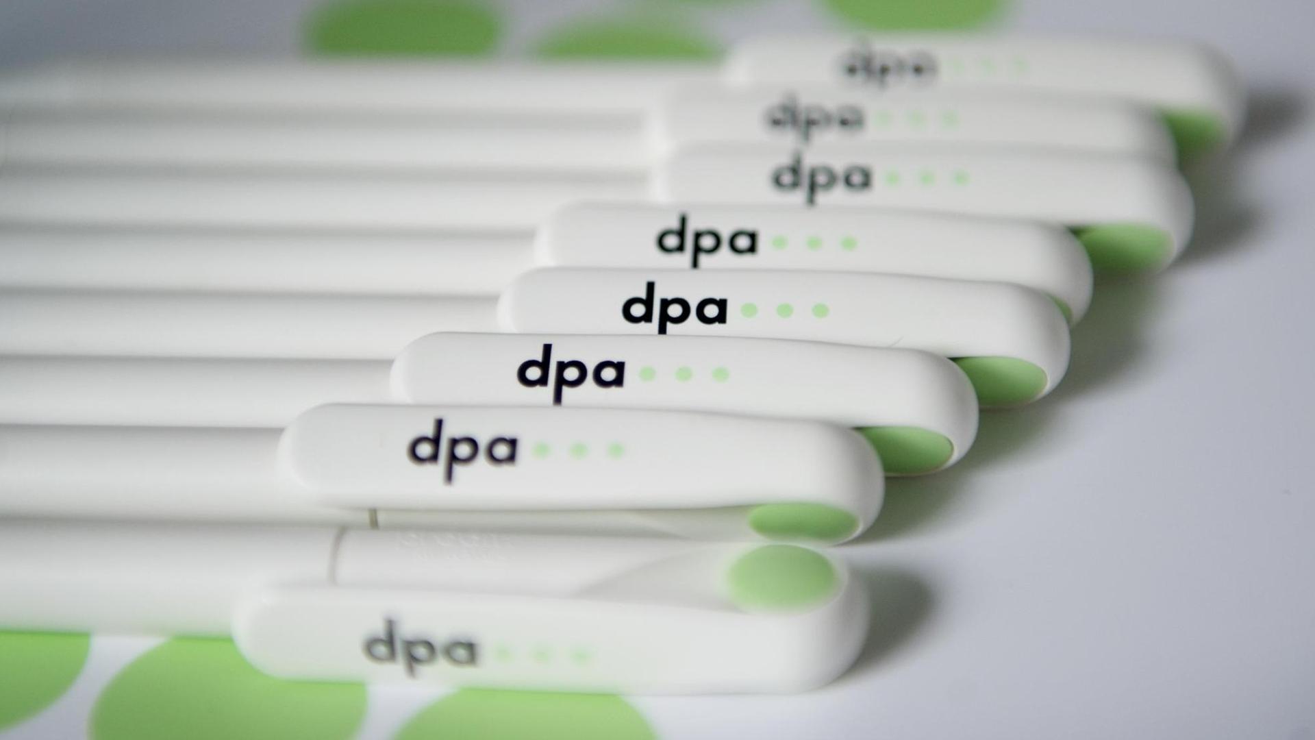 Kugelschreiber mit dem dpa-Logo liegen am Mittwoch (29.06.2011) auf einer Mappe während einer Pressekonferenz der dpa. Kugelschreiber mit dem dpa-Logo liegen am Mittwoch (29.06.2011) auf einer Mappe während einer Pressekonferenz der dpa.
