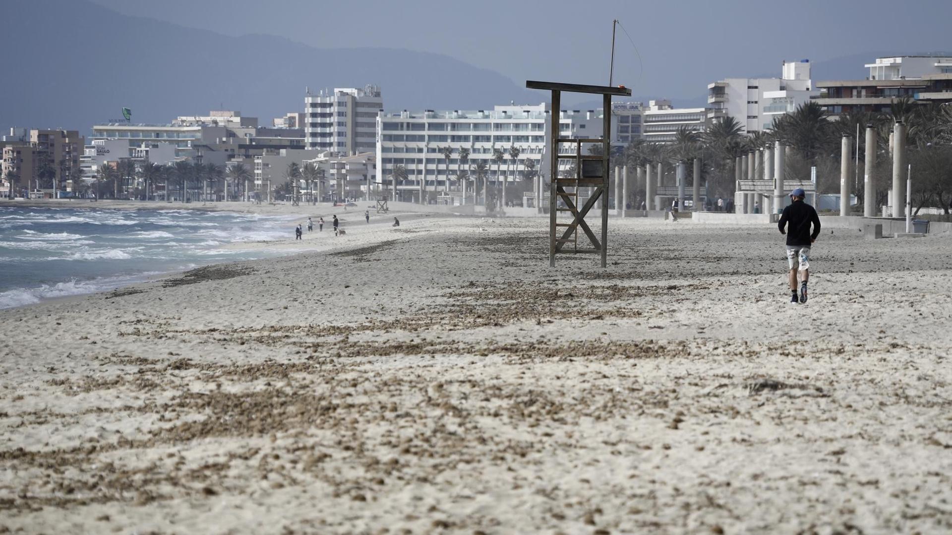 Ein Mann geht am Strand von Arenal auf Mallorca über den Sand. Deutsche Reiseveranstalter hoffen, dass sie Urlauber ab den Osterferien wieder nach Mallorca bringen können. Ein Mann geht am Strand von Arenal auf Mallorca über den Sand. Deutsche Reiseveranstalter hoffen, dass sie Urlauber ab den Osterferien wieder nach Mallorca bringen können.