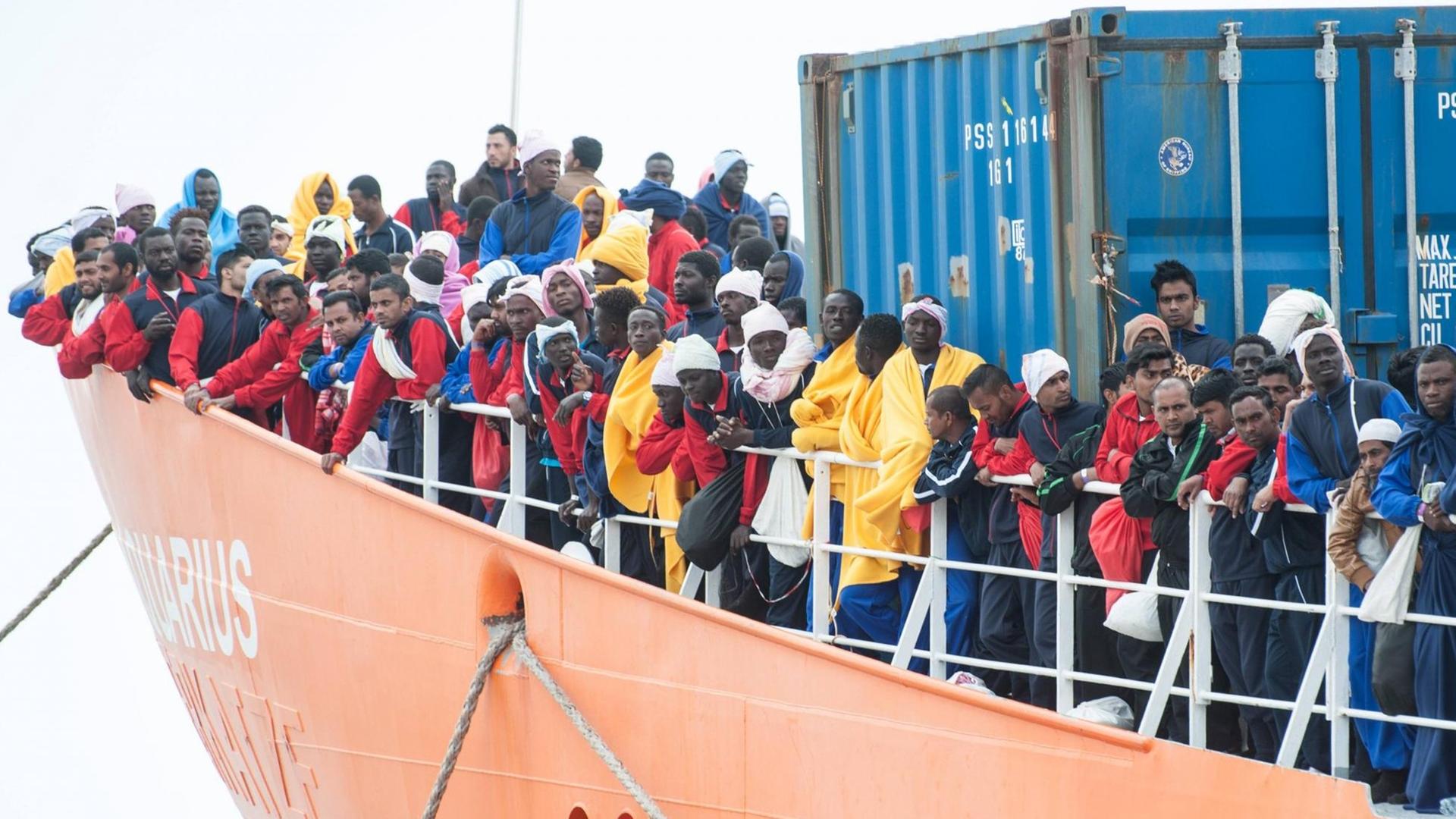 Flüchtlinge stehen an der Reeling eines Rettungsschiffs. Flüchtlinge stehen an der Reeling eines Rettungsschiffs.