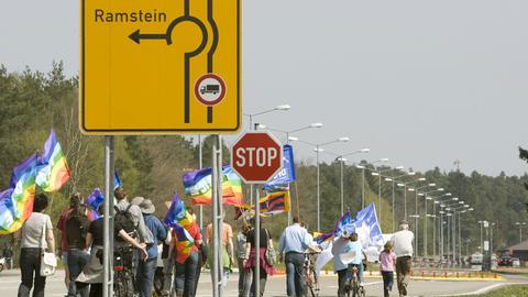 Demonstranten laufen auf der Zufahrt zur amerikanischen Air Base Ramstein Richtung Landstuhl.
