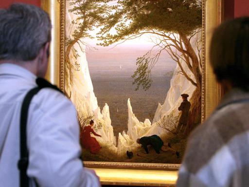 Besucher betrachten das Gemälde "Kreidefelsen auf Rügen" von Caspar David Friedrich während der Ausstellung "Die Erfindung der Romantik" im Museum Folkwang in Essen.