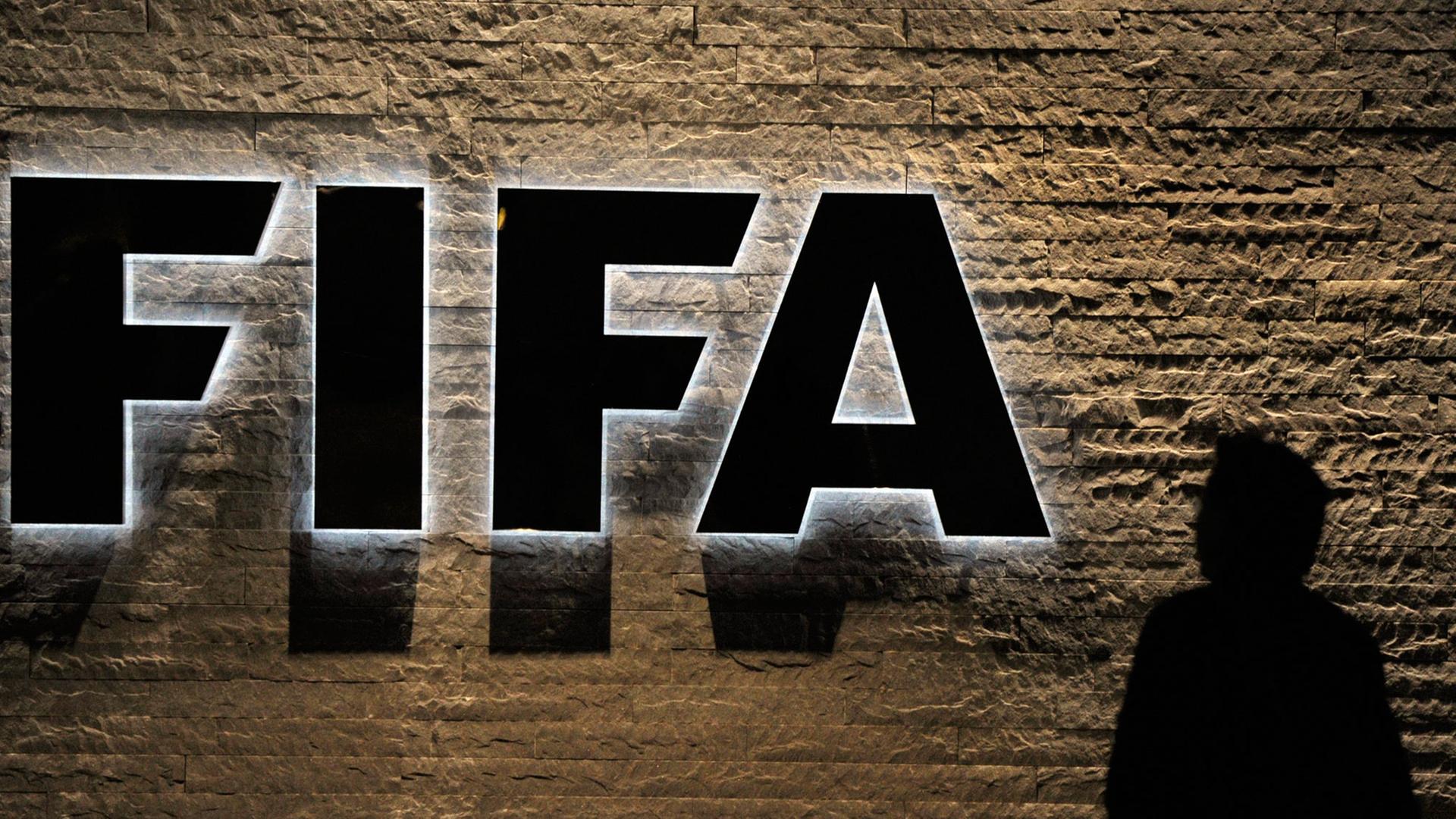 Das Fifa-Logo, daneben die Silhouette einer Person. Das Fifa-Logo, daneben die Silhouette einer Person.