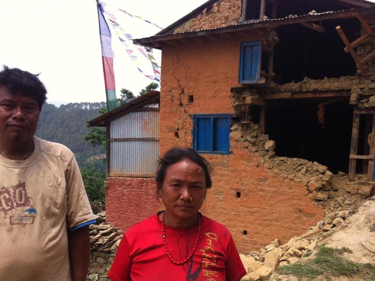 Die Dorfbewohner Dorji Lama und seine Frau Srimaya vor ihrem Haus, das bei dem Nachbeben im nepalesischen Irkhu am vergangenen Dienstag schwer beschädigt wurde