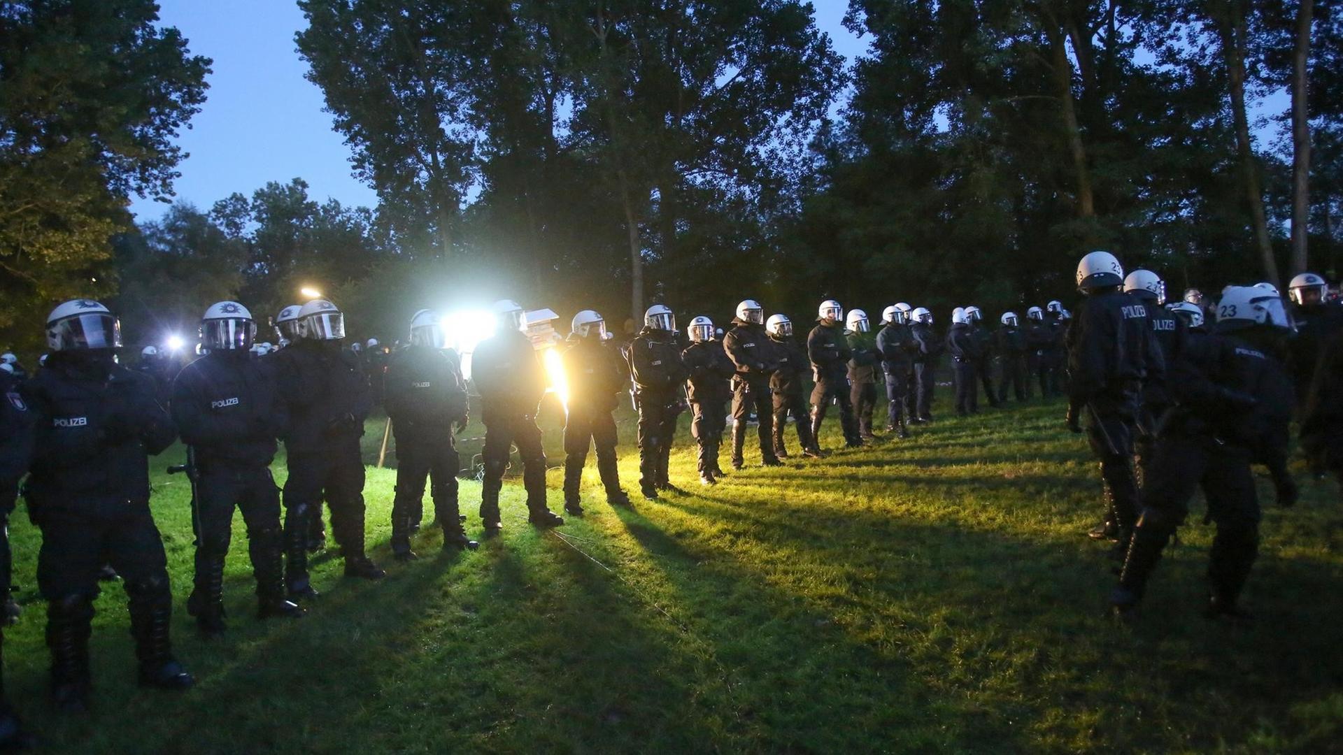 Polizisten stehen am 02.07.2017 in Hamburg bei der Beschlagnahmung von Schlafzelten in einem Protest-Camp gegen den G20-Gipfel auf der Elbhalbinsel Entenwerder. Nach einer Entscheidung des Hamburger Verwaltungsgerichts über ein G20-Protest-Camp auf der Elbhalbinsel Entenwerder hat die Polizei das Übernachten in dem Camp verboten. Foto: Bodo Marks/dpa | Verwendung weltweit Polizisten stehen am 02.07.2017 in Hamburg bei der Beschlagnahmung von Schlafzelten in einem Protest-Camp gegen den G20-Gipfel auf der Elbhalbinsel Entenwerder. Nach einer Entscheidung des Hamburger Verwaltungsgerichts über ein G20-Protest-Camp auf der Elbhalbinsel Entenwerder hat die Polizei das Übernachten in dem Camp verboten. Foto: Bodo Marks/dpa | Verwendung weltweit