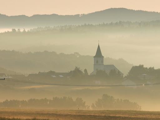 Über Nebelschwaden geht die Sonne am Montagmorgen (23.07.2007) über Üxheim in der Vulkaneifel an der Landesgrenze von Nordrhein-Westfalen und Rheinland-Pfalz auf.