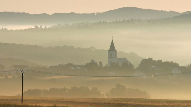 Über Nebelschwaden geht die Sonne am Montagmorgen (23.07.2007) über Üxheim in der Vulkaneifel an der Landesgrenze von Nordrhein-Westfalen und Rheinland-Pfalz auf.