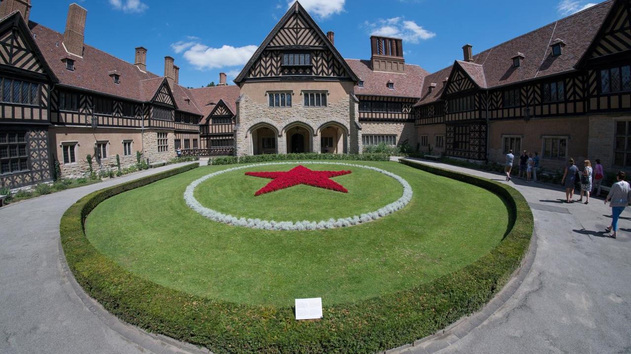 Der Innenhof von Schloss Cecilienhof. Auf der Rasenfläche im Ehrenhof befindet sich ein fünfzackiger Sowjetstern aus roten Blumen. Der Innenhof von Schloss Cecilienhof. Auf der Rasenfläche im Ehrenhof befindet sich ein fünfzackiger Sowjetstern aus roten Blumen.