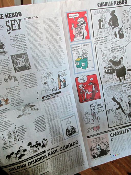 Eine Frau blättert am 14.01.2015 in Istanbul in der Zeitung "Cumhuriyet", die vier Seiten der neuen Ausgabe von "Charlie Hebdo" als Beilage nachdruckte.