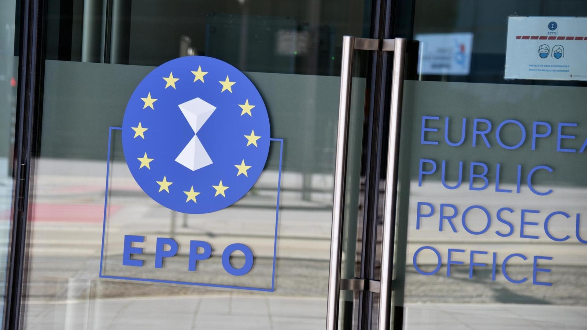 Das Emblem der Europäischen Staatsanwaltschaft, EuStA, (englisch European Public Prosecutors Office, EPPO), auf einer Glasüre zum Bürogebäude. Das Emblem der Europäischen Staatsanwaltschaft, EuStA, (englisch European Public Prosecutors Office, EPPO), auf einer Glasüre zum Bürogebäude.