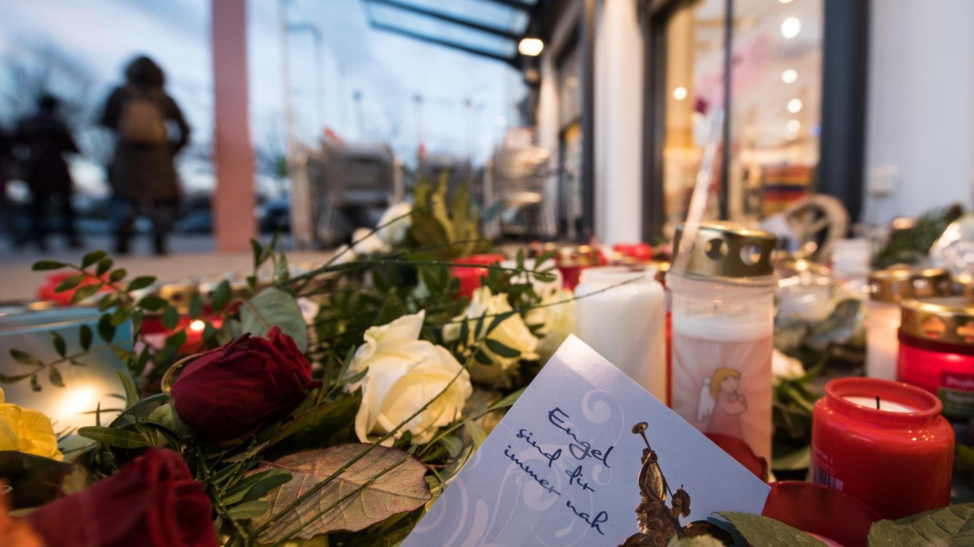 Ein Zettel mit der Aufschrift "Engel sind für immer nah" liegt am 28.12.2017 vor dem Drogeriemarkt in Kandel zwischen abgelegten Blumen und Kerzen