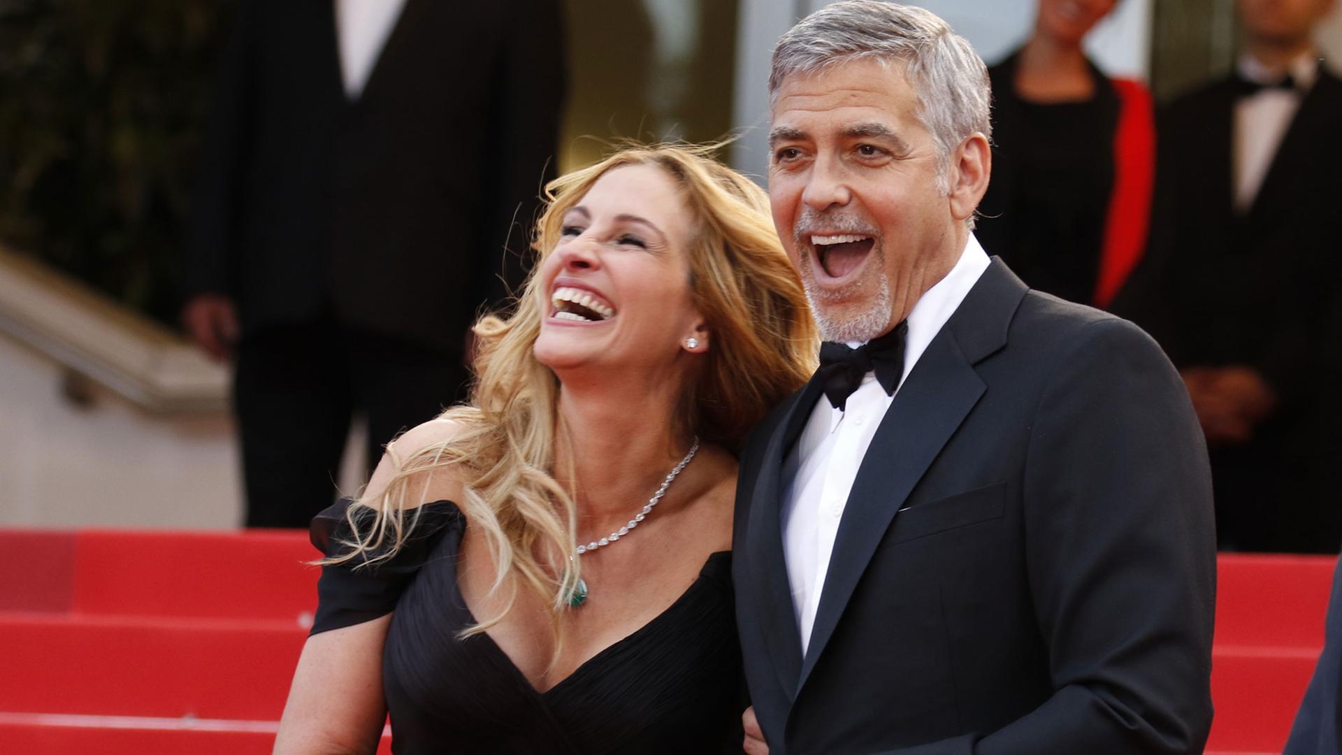Die US-Schauspieler Julia Roberts und George Clooney scherzen am 12.5.2016 bei der Premiere von "Money Monster" von Jodie Foster auf dem Roten Teppich beim Cannes Film Festival.
