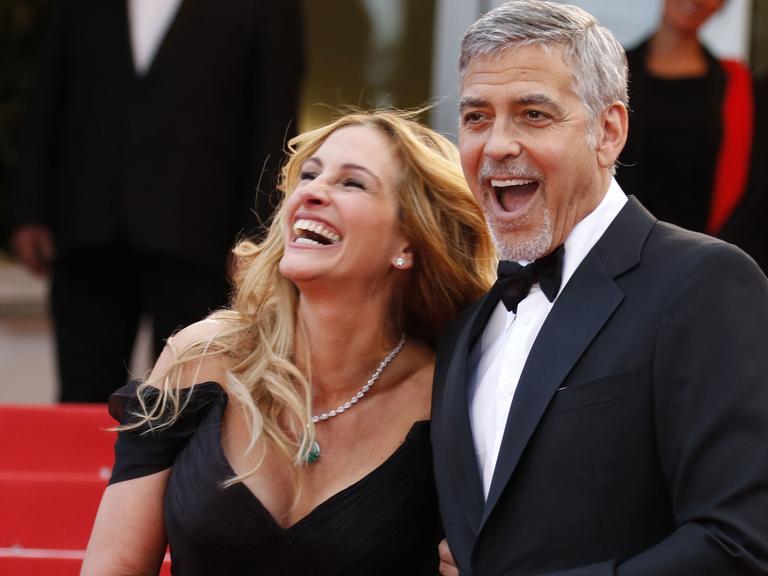 Die US-Schauspieler Julia Roberts und George Clooney scherzen am 12.5.2016 bei der Premiere von "Money Monster" von Jodie Foster auf dem Roten Teppich beim Cannes Film Festival.