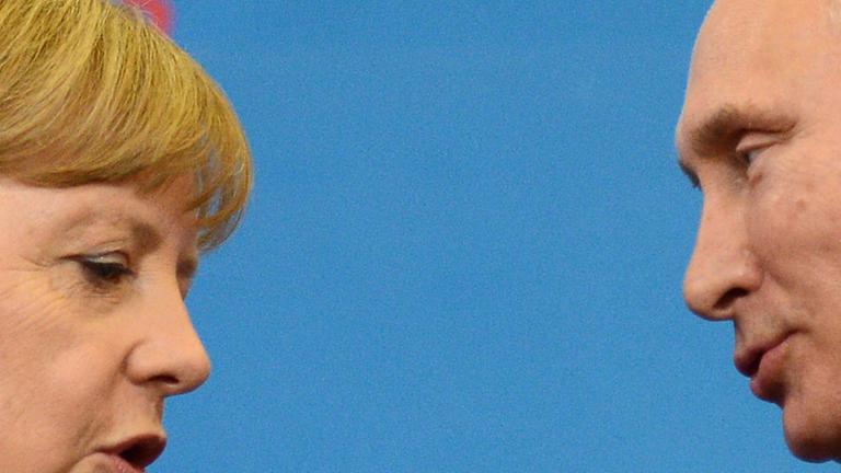 Angela Merkel spricht mit Wladimir Putin auf einer Konferenz 2013 in St. Petersburg. Angela Merkel spricht mit Wladimir Putin auf einer Konferenz 2013 in St. Petersburg.