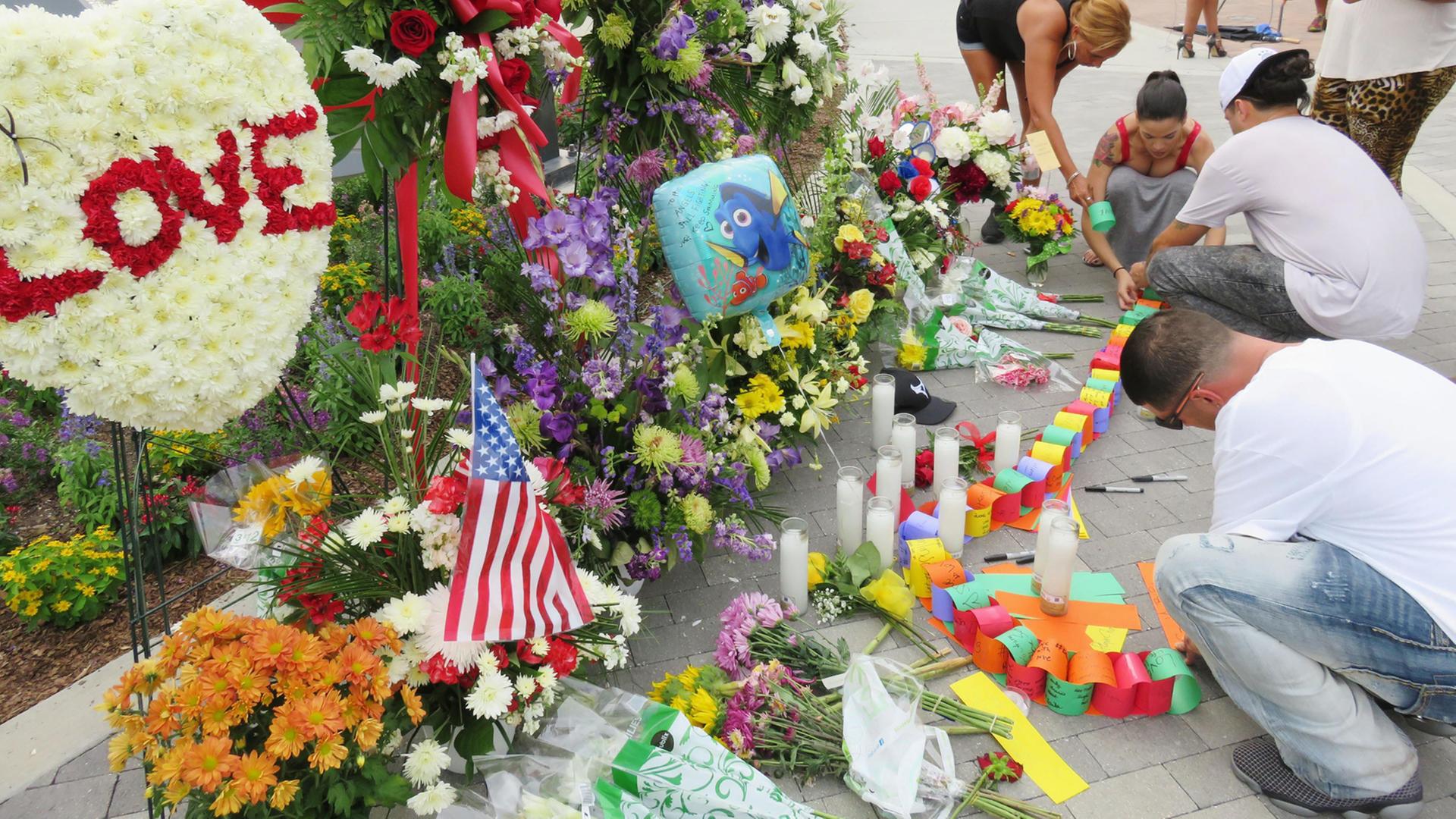 In Orlando/Florida legen Menschen Blumen nieder in Gedenken an die Opfer der Schießerei in einem Nachtclub. In Orlando/Florida legen Menschen Blumen nieder in Gedenken an die Opfer der Schießerei in einem Nachtclub.