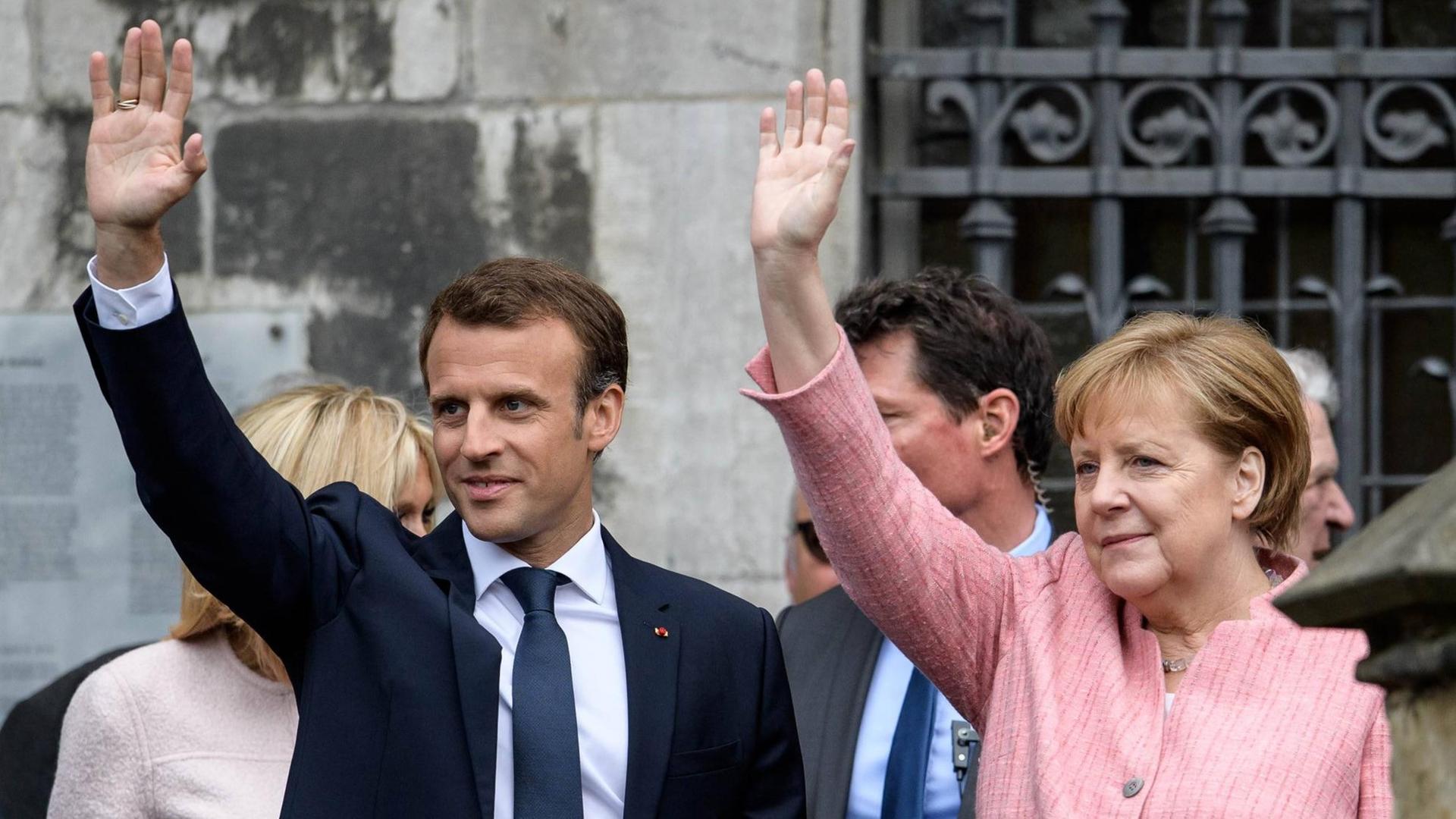 Bundeskanzlerin Angela Merkel (CDU), und der französische Staatspräsident Emmanuel Macron winken in die selbe Richtung. Bundeskanzlerin Angela Merkel (CDU), und der französische Staatspräsident Emmanuel Macron winken in die selbe Richtung.