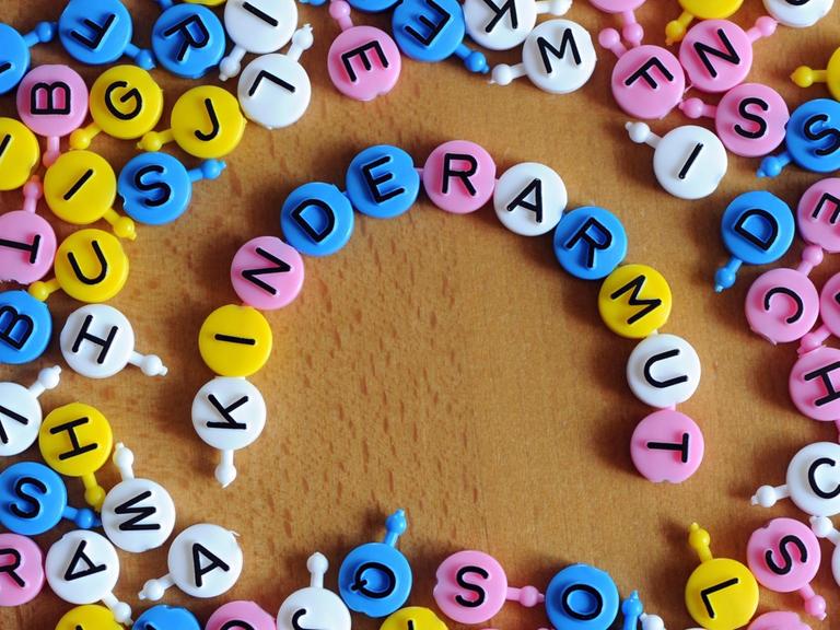 Aus einzelnen Buchstaben des Spiels "Buchstabensuppe" ist das Wort Kinderarmut gebildet