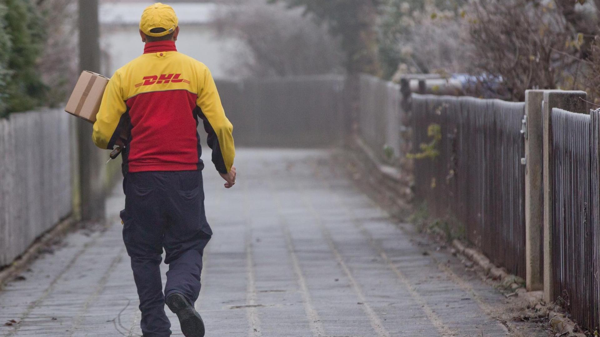 Ein DHL-Paketzusteller liefert Sendungen aus. Ein DHL-Paketzusteller liefert Sendungen aus.