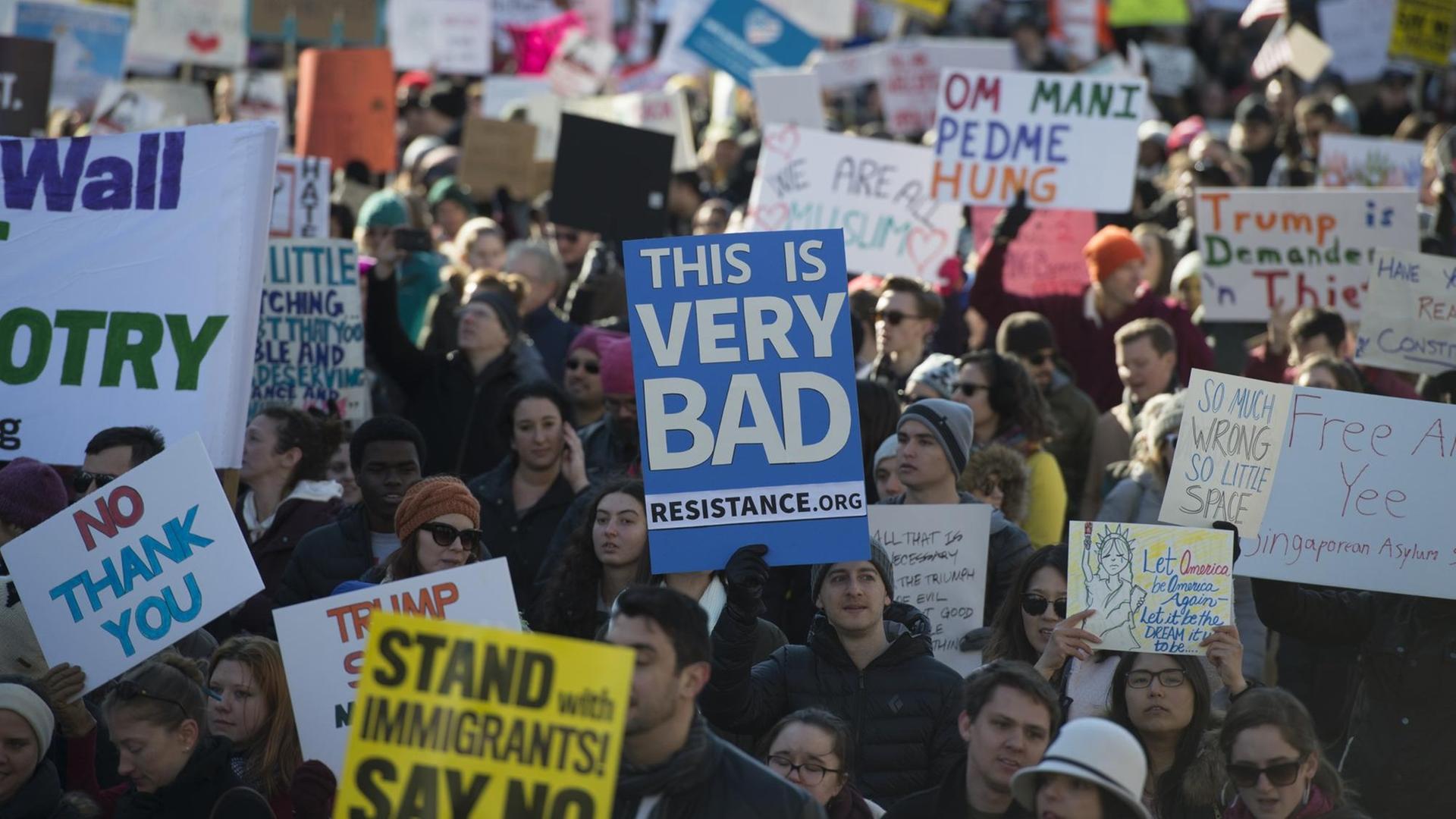 Demonstranten mit Plakaten gegen die Politik von US-Präsident auf der Pennsylvania Avenue in Washington D.C. Demonstranten mit Plakaten gegen die Politik von US-Präsident auf der Pennsylvania Avenue in Washington D.C.