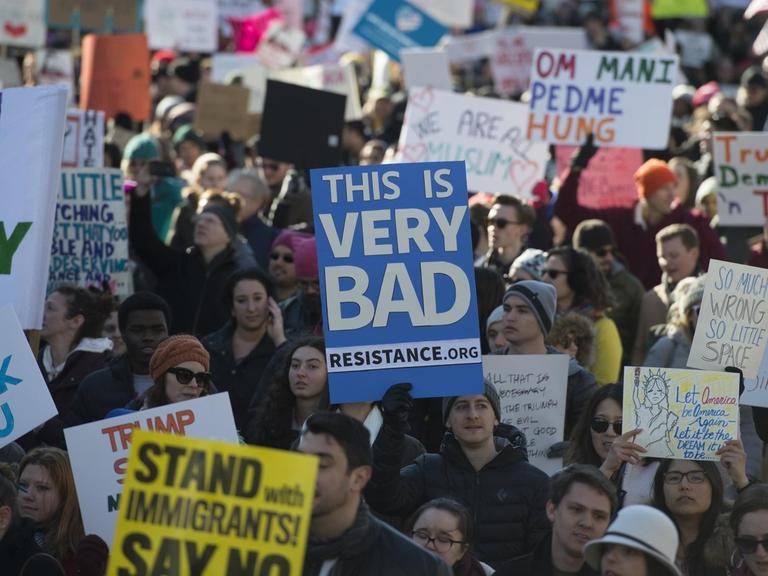 Demonstranten mit Plakaten gegen die Politik von US-Präsident auf der Pennsylvania Avenue in Washington D.C.