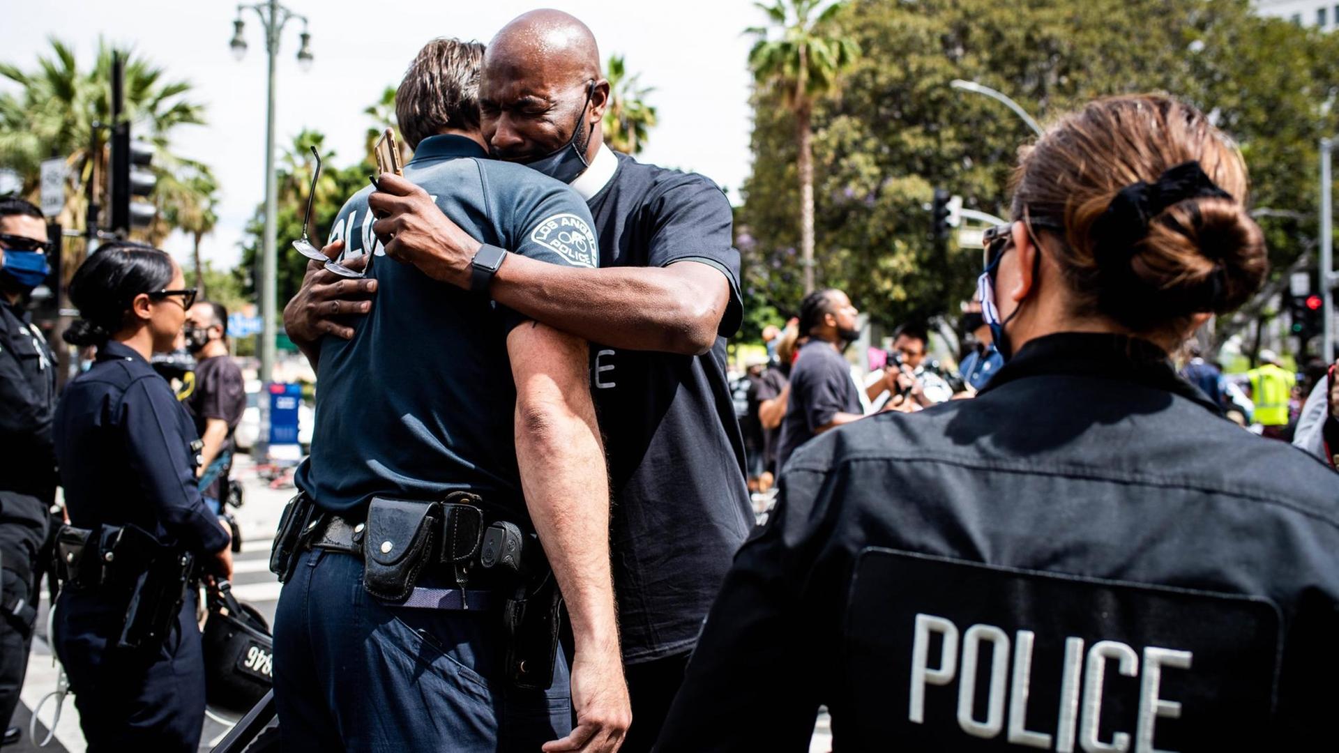 Ein Mann umarmt einen Polizisten Ein Mann umarmt einen Polizisten