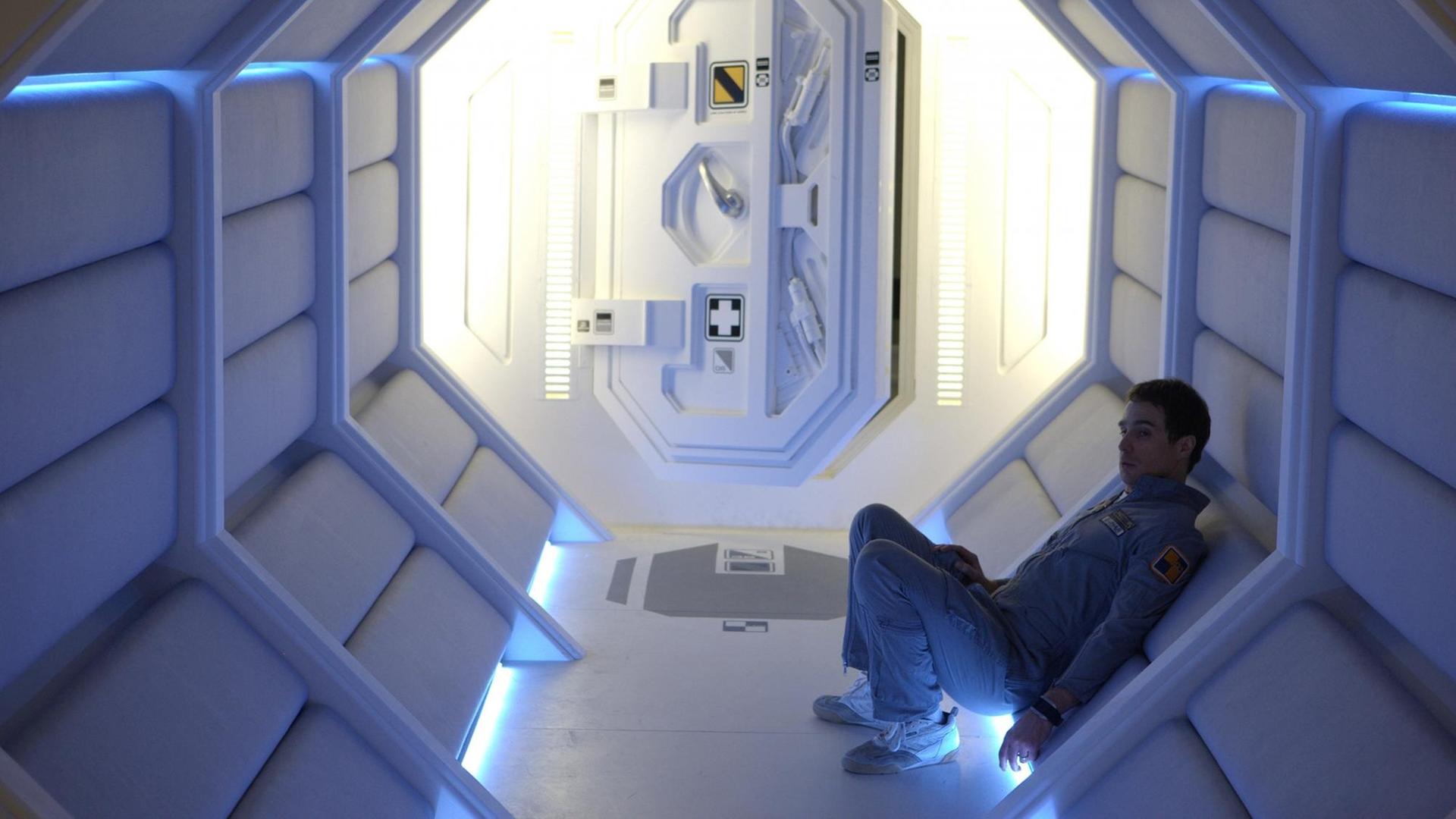 Sam Rockwell sitzt allein im Korridor einer Mondstation Sam Rockwell sitzt allein im Korridor einer Mondstation