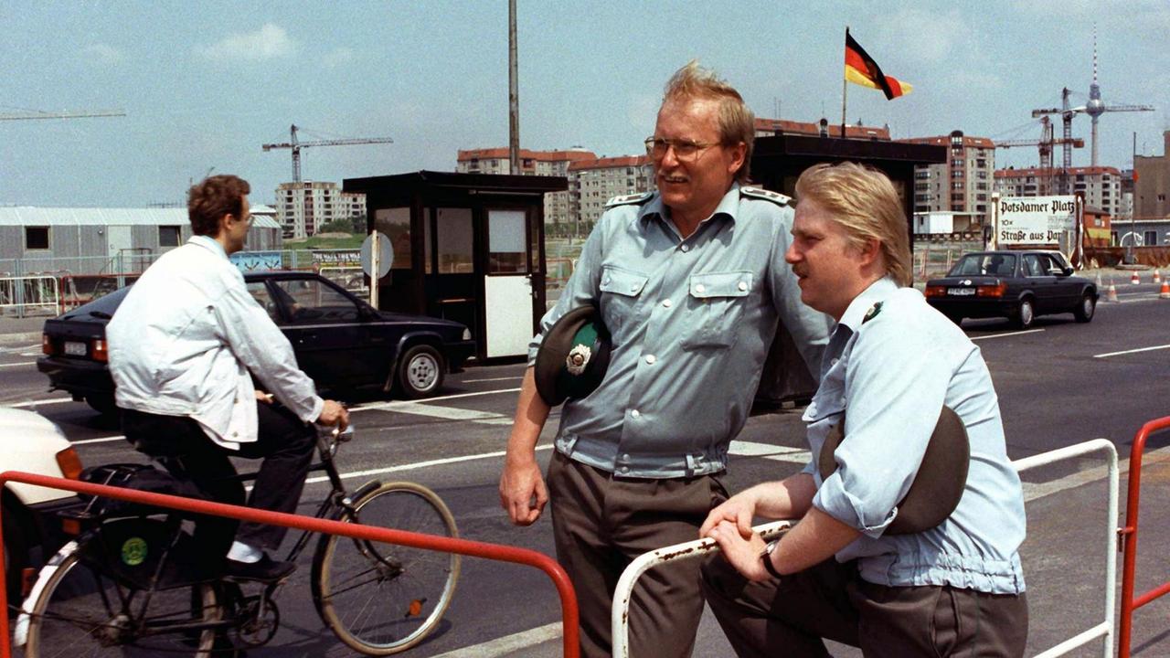DDR-Grenzsoldaten lassen am 29. Juni 1990 –zwei Tage vor Inkrafttreten des Staatsvertrages zwischen den beiden deutschen Staaten – Besucher am Potsdamer Platz in Ost-Berlin ungehindert passieren. DDR-Grenzsoldaten lassen am 29. Juni 1990 –zwei Tage vor Inkrafttreten des Staatsvertrages zwischen den beiden deutschen Staaten – Besucher am Potsdamer Platz in Ost-Berlin ungehindert passieren.