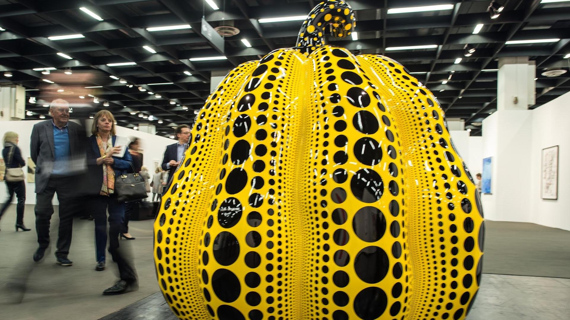 Ein Besucher geht in Köln am Kunstwerk "Pumpkin" aus dem Jahr 2016 von Yayoi Kusama vorbei. Ein Besucher geht in Köln am Kunstwerk "Pumpkin" aus dem Jahr 2016 von Yayoi Kusama vorbei.
