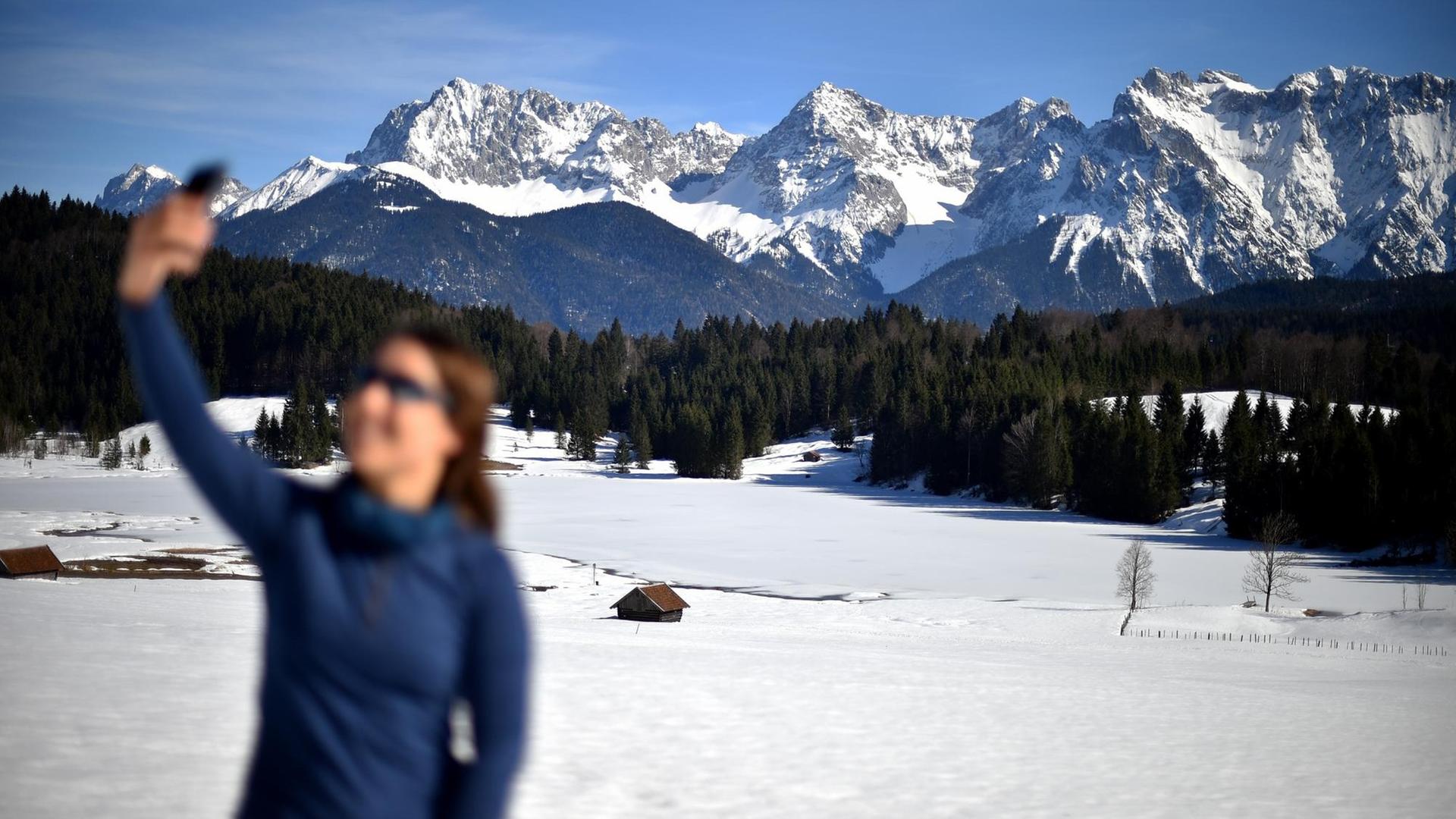 Eine Frau fotografiert sich selbst vor dem Karwendel-Gebirge (Selfie). Eine Frau fotografiert sich selbst vor dem Karwendel-Gebirge (Selfie).
