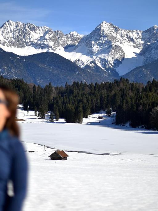 Eine Frau fotografiert sich selbst vor dem Karwendel-Gebirge (Selfie).