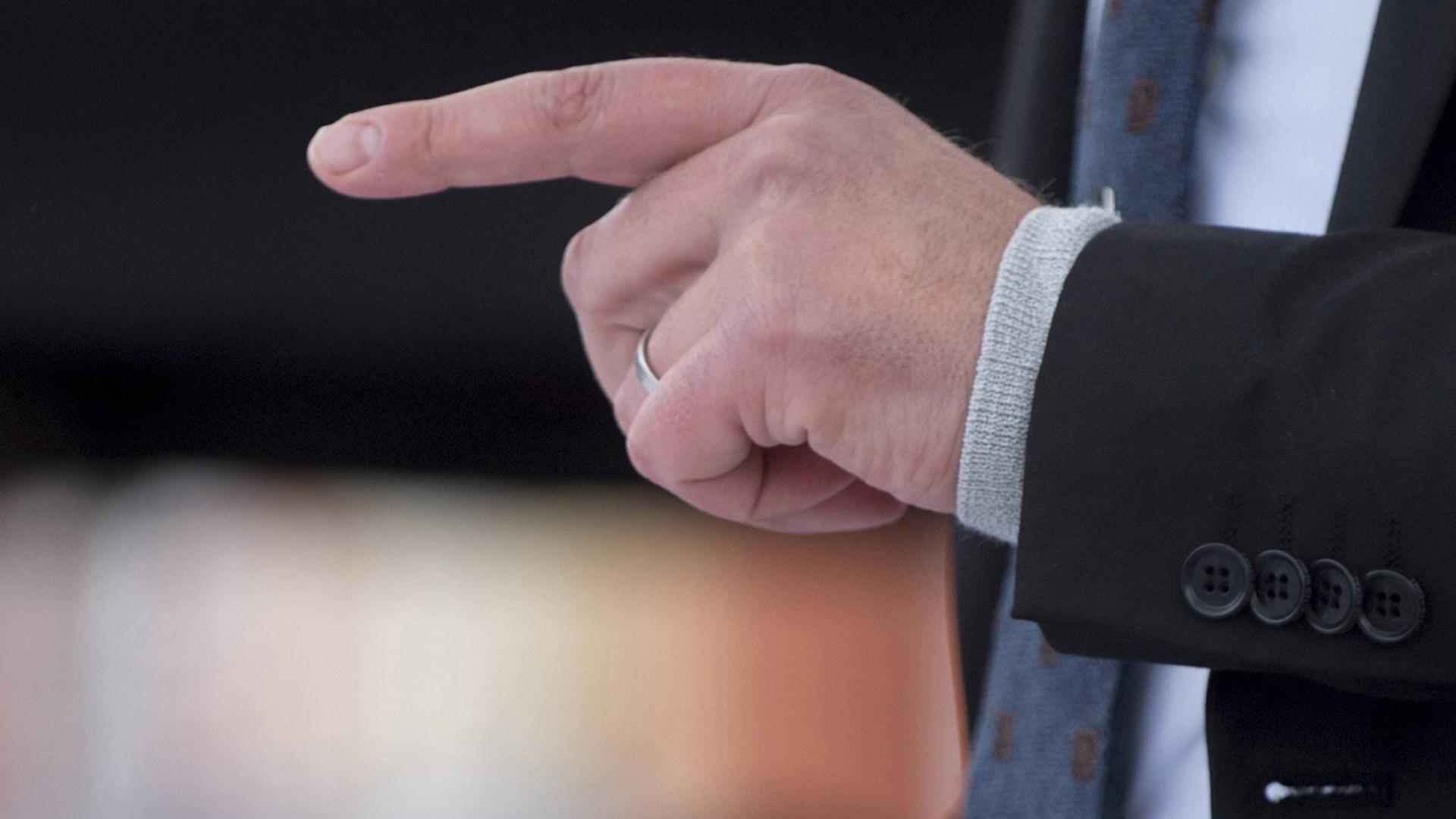 Ein Politiker schwingt bei einer Rede den Zeigefinger Ein Politiker schwingt bei einer Rede den Zeigefinger